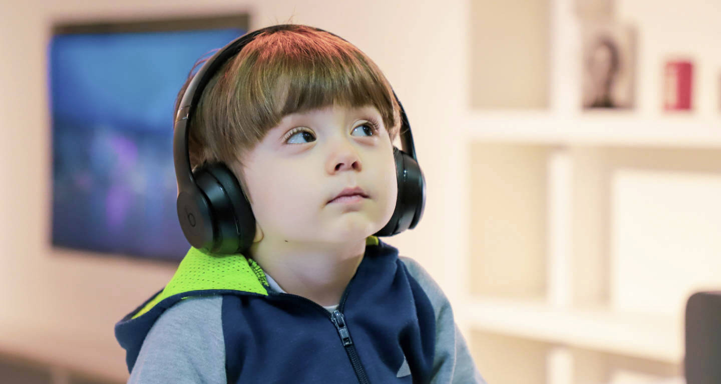 Junge hört Podcast über Kopfhörer