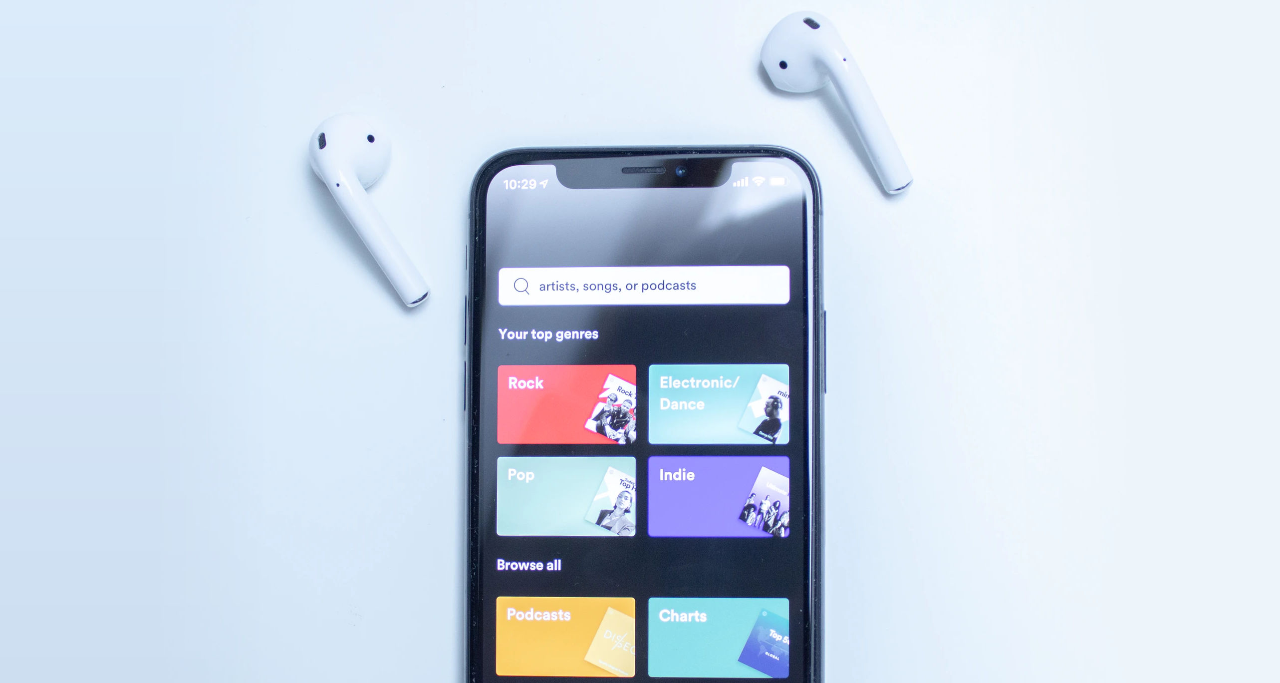 iPhone mit Spotify App und Airpods